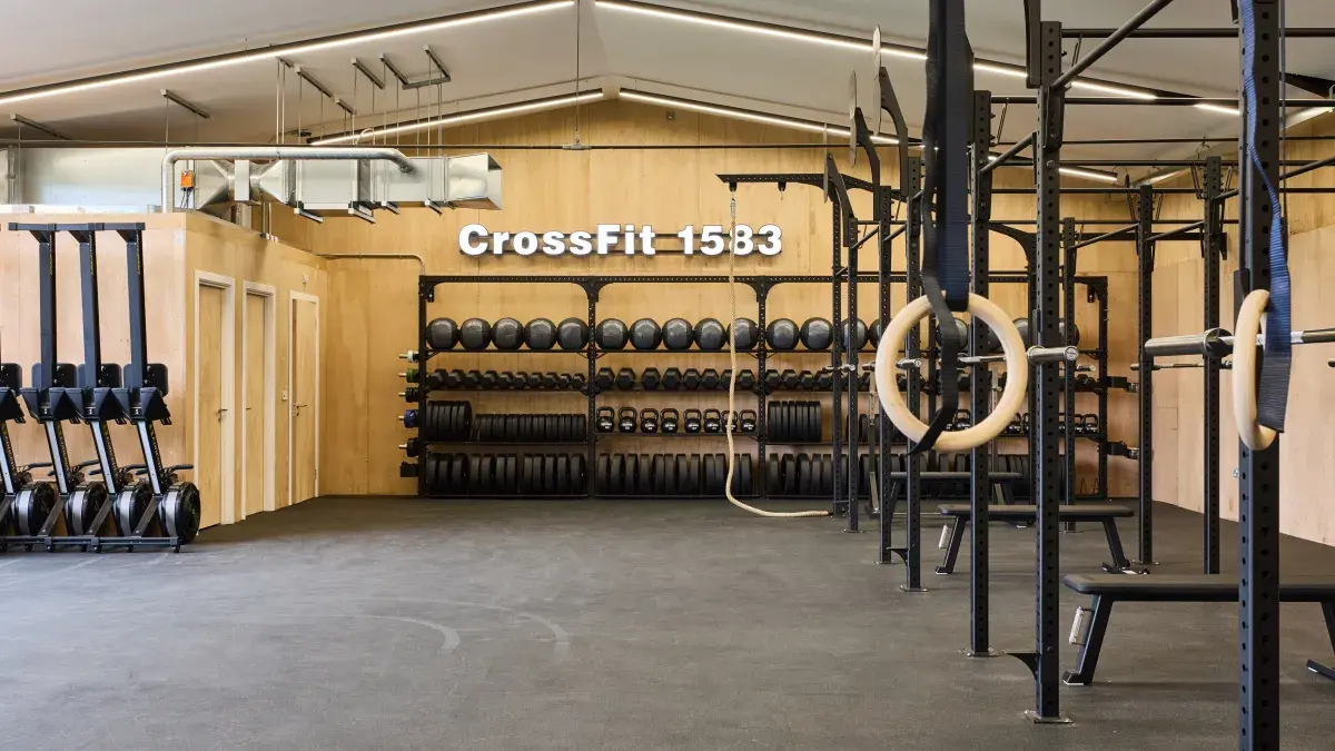 CrossFit gym with black equipment around room and wooden walls 