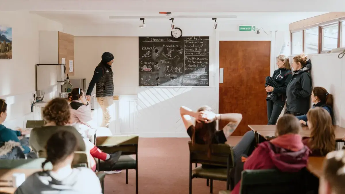 group looking to the front of the room with someone presenting