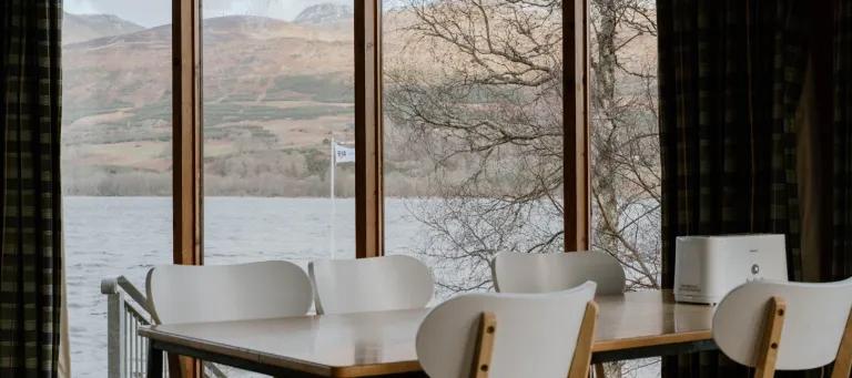 chairs infront of a big window looking at over a loch