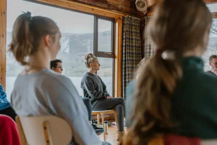 Wellbeing session, people sat in a circle in wooden room